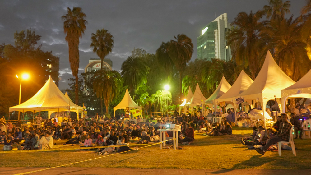 Shir Shir Bazaar — the site after dark, crowd gathered between the tents